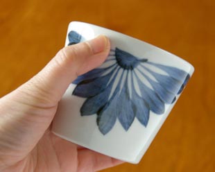 砥部焼・梅山窯　菊もようのそばちょこにを手に持って