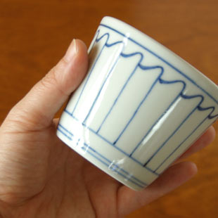 砥部焼・梅山窯　波とくさのそばちょこを手に持って