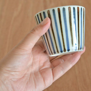 砥部焼・梅山窯　鉄ごすとくさのそばちょこを手に持って