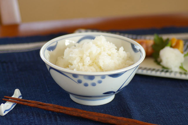 砥部焼・梅山窯　太陽柄の反茶碗にご飯をよそって