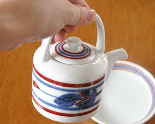 砥部焼・梅山窯　みつ葉の醤油さし（大）を手に持って