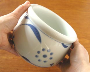 砥部焼・梅山窯　太陽のがらいれを手に持って