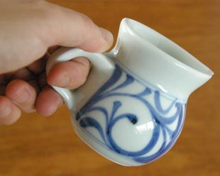 砥部焼・梅山窯　からくさの手付クリーマーを手に持って