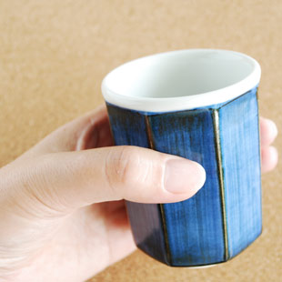 砥部焼・梅山窯　藍色の八角湯呑(小)を手に持って