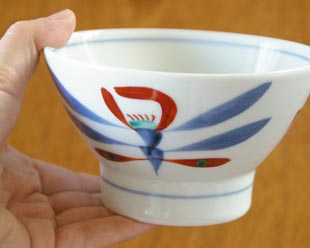 砥部焼・梅山窯　あか花の茶碗（大）を手に持って