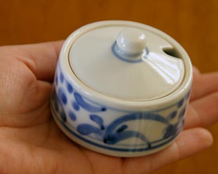 砥部焼・梅山窯　太陽柄の薬味入れを手に持って