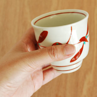 砥部焼・梅山窯　赤笹の湯呑を手に持って