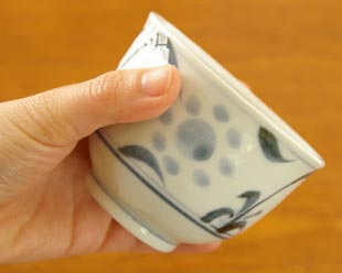砥部焼・梅山窯　太陽柄の湯呑を手に持って