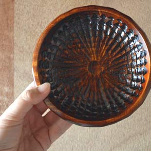 香川漆器　ハツリノミ彫の茶托を手に持って
