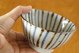 砥部焼・森陶房　麦わらの茶碗(大)を手に持って