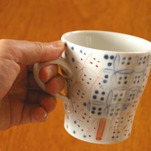 砥部焼・陶房遊　彩り紋のマグカップ（小）を手に持って