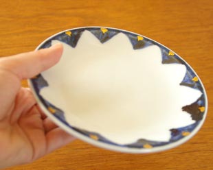 砥部焼・西岡工房　ゴスペン金彩の取皿を手に持って