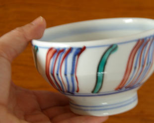 砥部焼・西岡工房　よろけもようの茶碗を手に持って