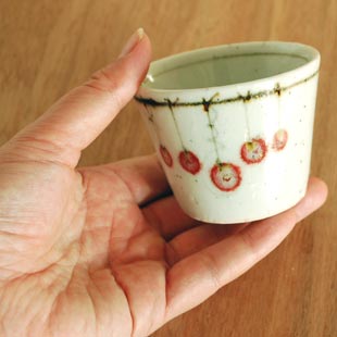 砥部焼・中田窯　吊るし柿のそばちょこを手に持って