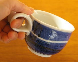 砥部焼・向井窯　青いコーヒーカップを手に持って