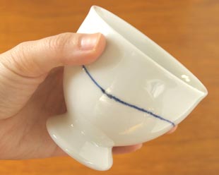 砥部焼・向井窯　白いフリーカップを手に持って