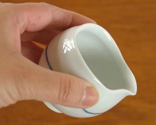 砥部焼・向井窯　白いミルク入れを手に持って