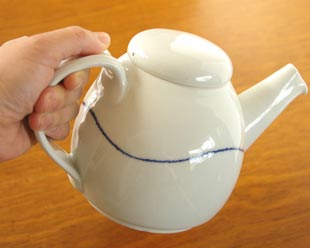 砥部焼・向井窯　白いティーポットを手に持って