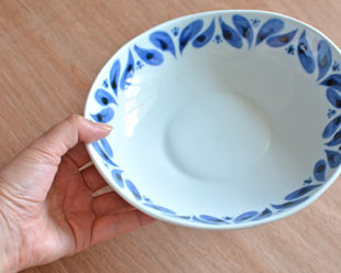 砥部焼・陶房遊　ブルーフラワーのカレー鉢を手に持って