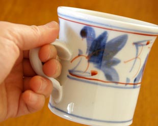 砥部焼・陶房遊　しだ紋のマグカップを手に持って