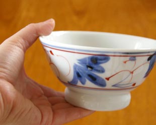 砥部焼・陶房遊　しだ紋の茶碗(大)を手に持って