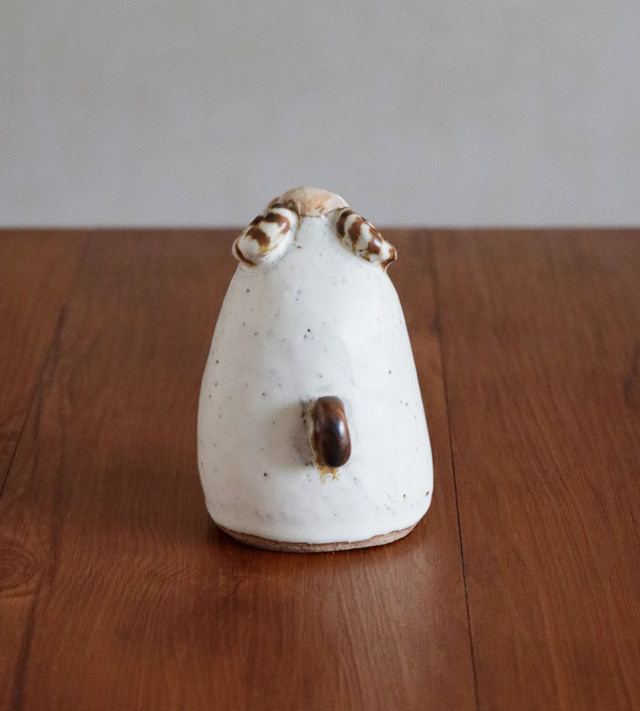 小さな茶色いしっぽがついた巻角ひつじの後ろ姿