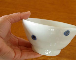 砥部焼・梅乃瀬窯　水玉もようの茶碗を手に持って