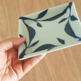 砥部焼・雲石窯　三つ葉の正角皿を手に持って