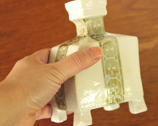 砥部焼・砥部焼　足つきの角花びんを手に持って