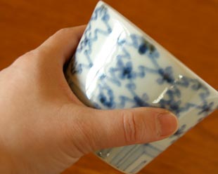 砥部焼・山中窯　菱紋のそばちょこを手に持って
