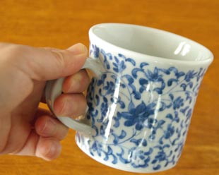 砥部焼・陽貴窯　菊唐草のマグカップを手に持って
